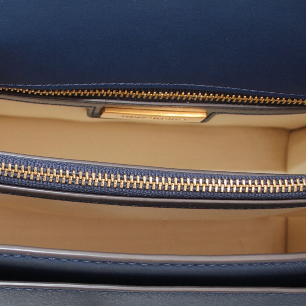 Navy crossbody bag interior with tan lining and gold-tone zipper closure