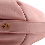 Pink leather hobo bag with gold crown logo snap and side seam detail