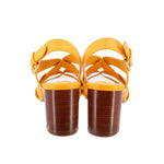 Yellow heeled sandals from back view with ankle straps and stacked heel