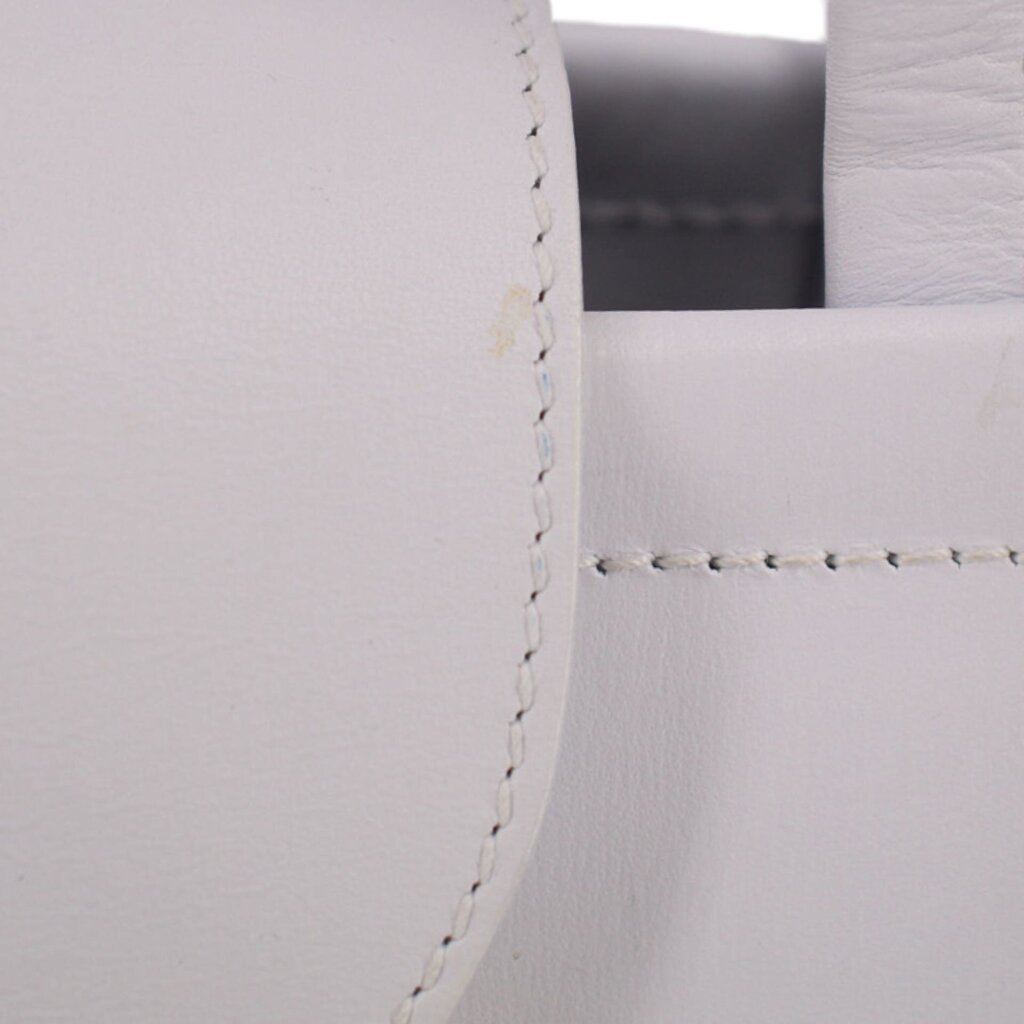 Close-up of stitched seam on white leather crossbody tote corner