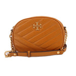 Orange Kira camera crossbody bag with quilted panels and logo medallion, chain strap