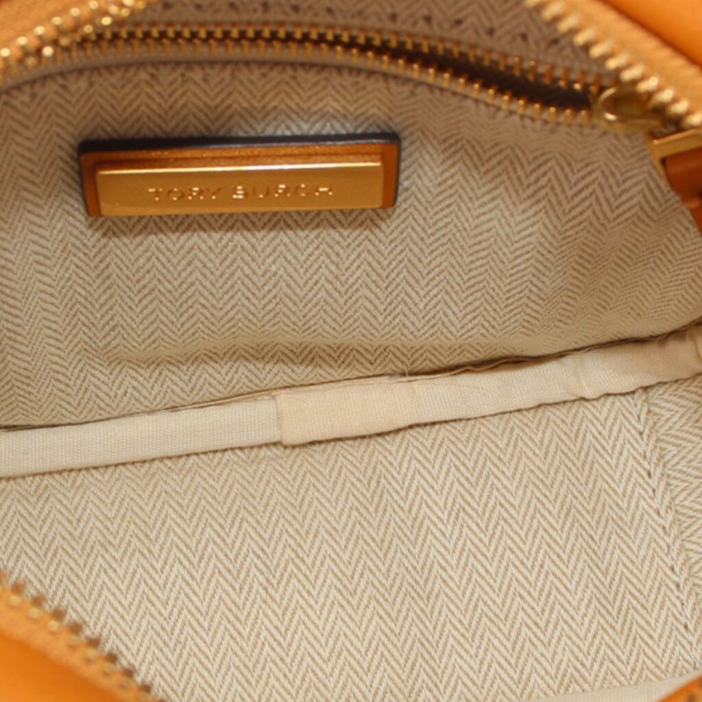 Beige herringbone fabric interior with TORY BURCH logo patch inside zippered bag