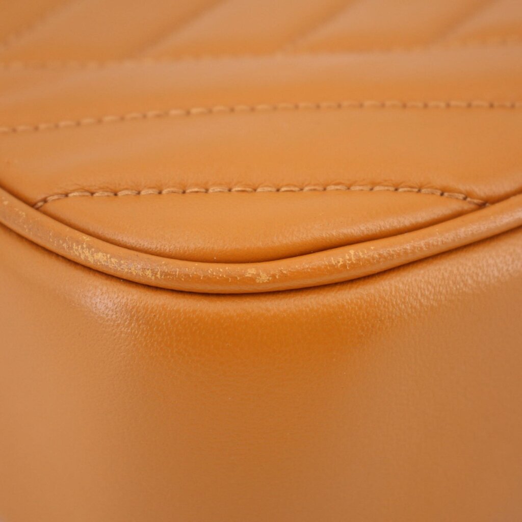 Orange leather panel seam close-up with curved stitching on Kira crossbody bag