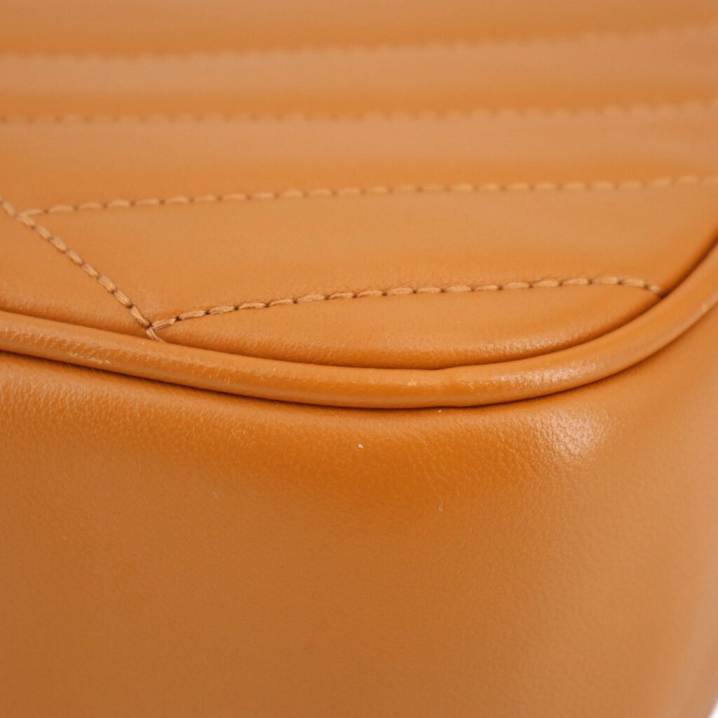 Orange leather trim close-up with stitched curved seam on Kira crossbody bag