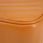 Orange leather trim close-up with stitched curved seam on Kira crossbody bag