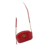 Red quilted leather camera crossbody bag with GG logo, worn as a crossbody