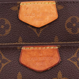 Close-up of tan leather tabs stamped 'Louis Vuitton Paris' on monogram Multi Pochette