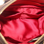Crossbody bag open interior with red satin-like lining and zipper trim