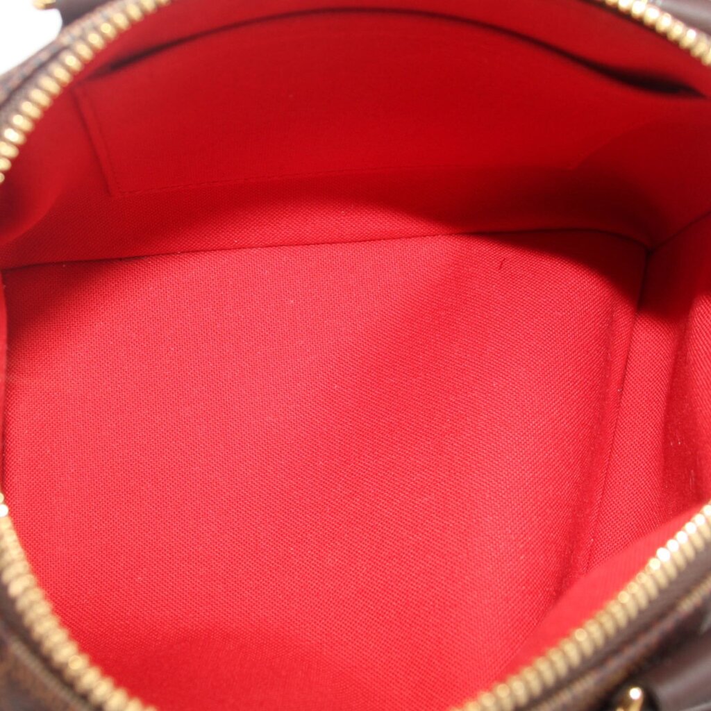 Crossbody bag interior lining in red fabric with visible zipper edge