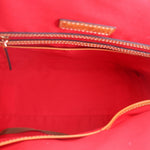 Carissa satchel interior with red lining and top zip closure, tan zipper pull label.