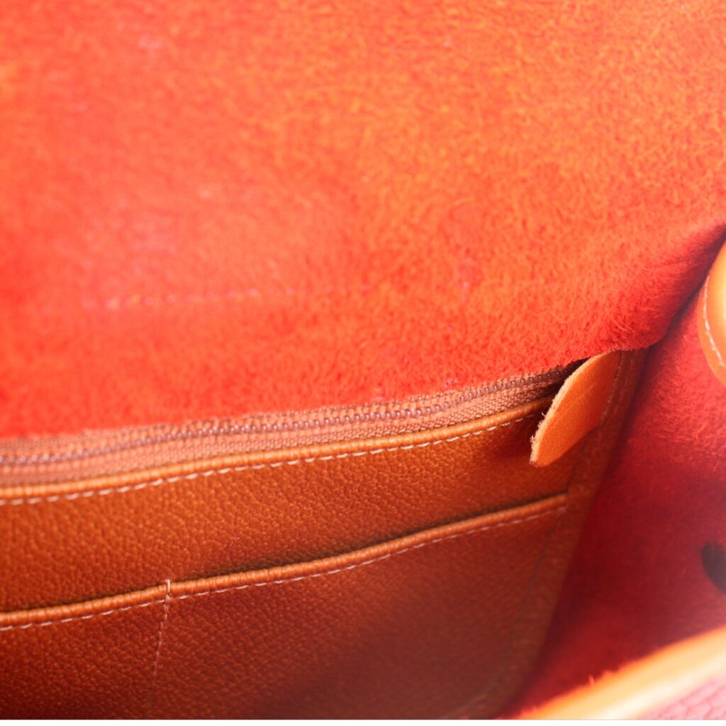 Close-up of red crossbody inner pocket seam and tan leather trim