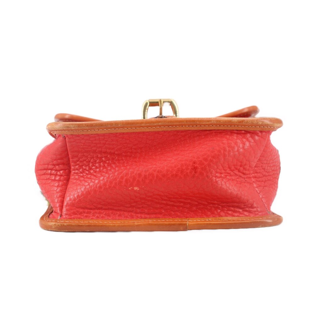 Red crossbody bag bottom edge with tan leather base and small top carry loop