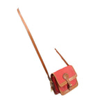 Red mini crossbody bag with tan-trim flap and long adjustable shoulder strap