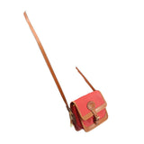 Red mini crossbody bag with tan-trim flap and long adjustable shoulder strap