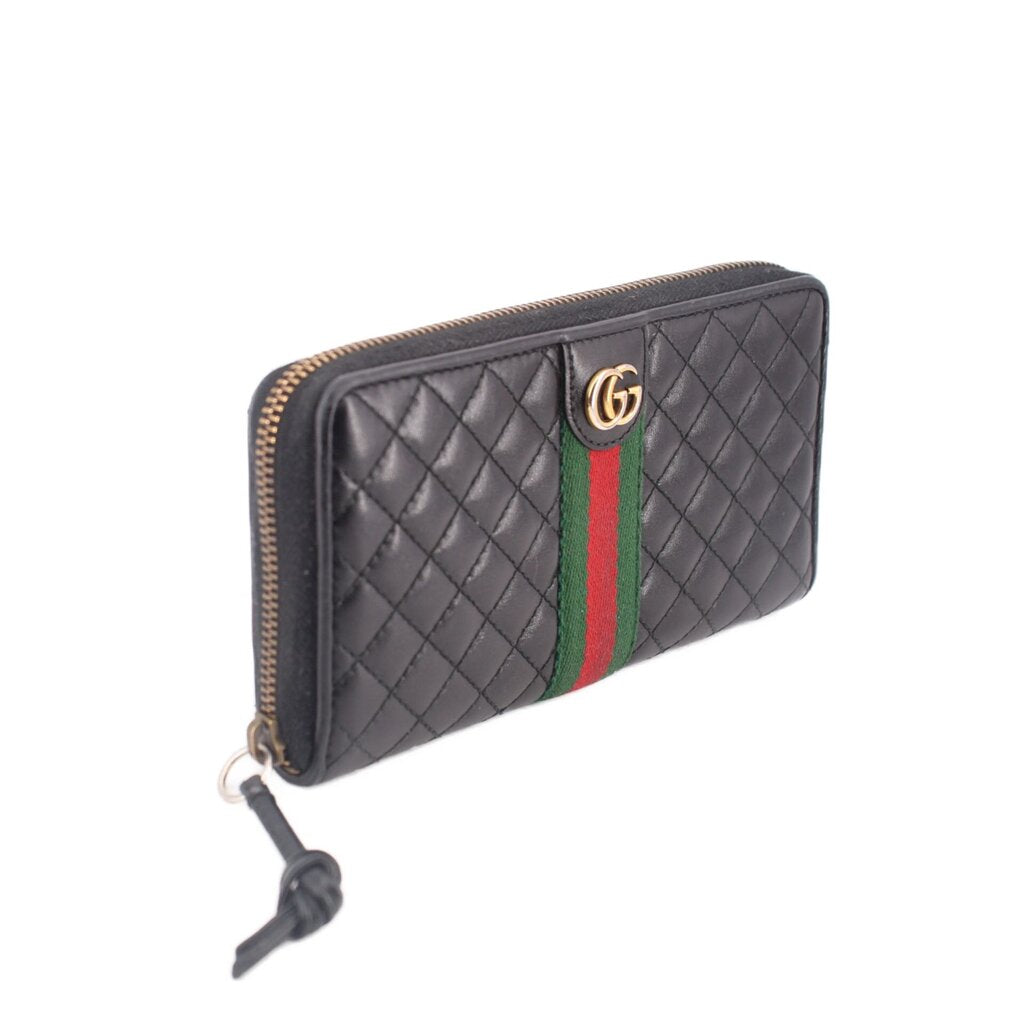 Black quilted wallet with gold-tone zipper and green/red Web stripe, side view.