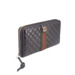 Black quilted wallet with gold-tone zipper and green/red Web stripe, side view.