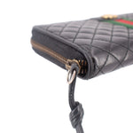 Black quilted wallet end with gold-tone zipper pull ring and attached cord.