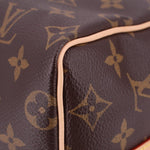 Louis Vuitton monogram bag edge close-up, dark brown canvas with tan leather trim