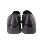 Back view of black leather loafers with low stacked heel and rounded heel counters