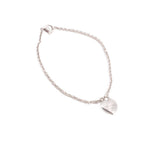 Silver heart charm bracelet with linked chain and heart pendant near edge