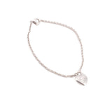 Silver heart charm bracelet with linked chain and heart pendant near edge