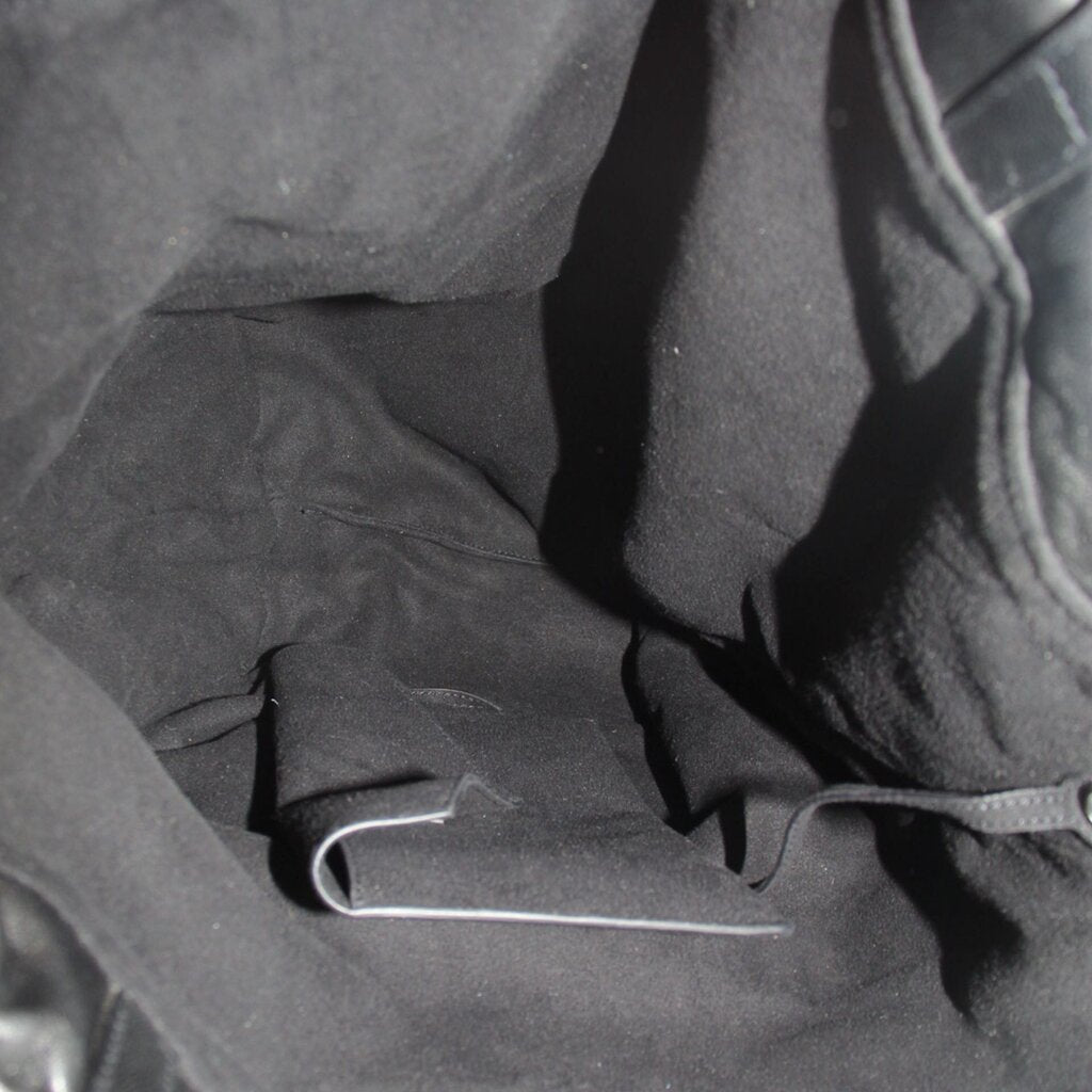 Interior of black drawstring tote bag with visible pocket and metal D-ring.