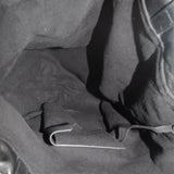 Interior of black drawstring tote bag with visible pocket and metal D-ring.