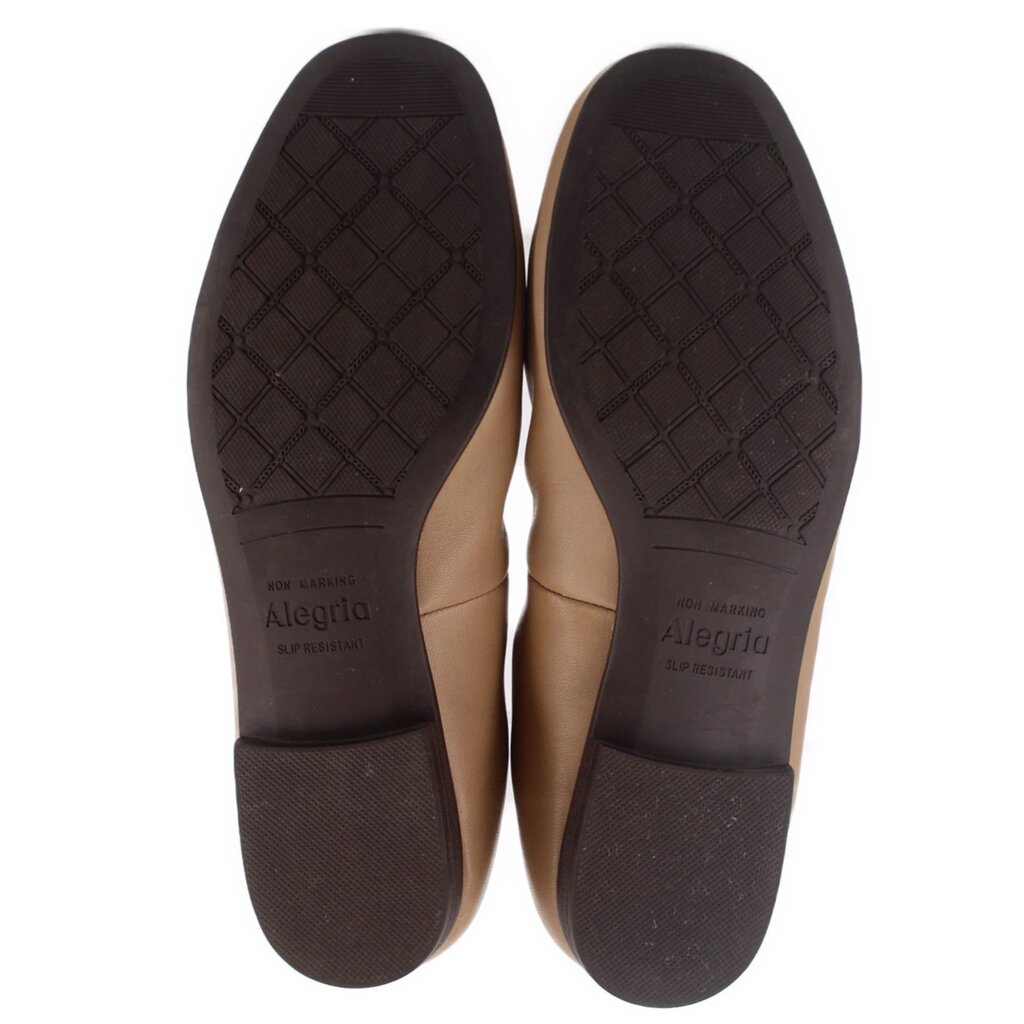 Tan leather flats outsole bottoms with textured tread, pair view