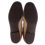 Tan leather flats outsole bottoms with textured tread, pair view