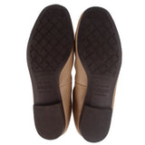 Tan leather flats outsole bottoms with textured tread, pair view