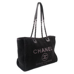 Black CHANEL tote bag with chain handles, rounded top, and front logo print
