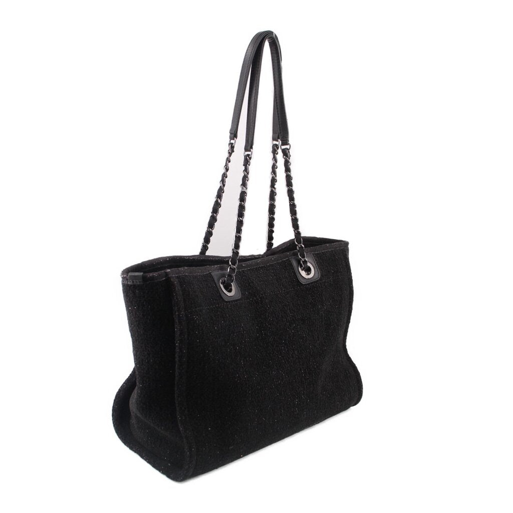 Black CHANEL tote bag with chain handles and structured side profile