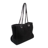 Black CHANEL tote bag with chain handles and structured side profile