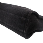 Black CHANEL tote bag corner with stitched fabric seam and rounded base