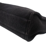 Black CHANEL tote bag corner with stitched fabric seam and rounded base