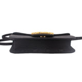 Black crossbody bag with gold-tone logo emblem on the front