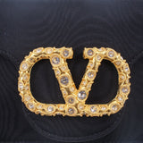 Black bag front with large gold-tone "V" logo and clear rhinestone trim