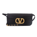 Black crossbody bag with gold-tone logo clasp and studded trim along the front flap