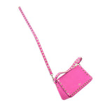 Pink small crossbody bag with gold Rockstud border and long shoulder strap