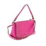 Pink crossbody bag with gold Rockstud border, top zip, and shoulder strap
