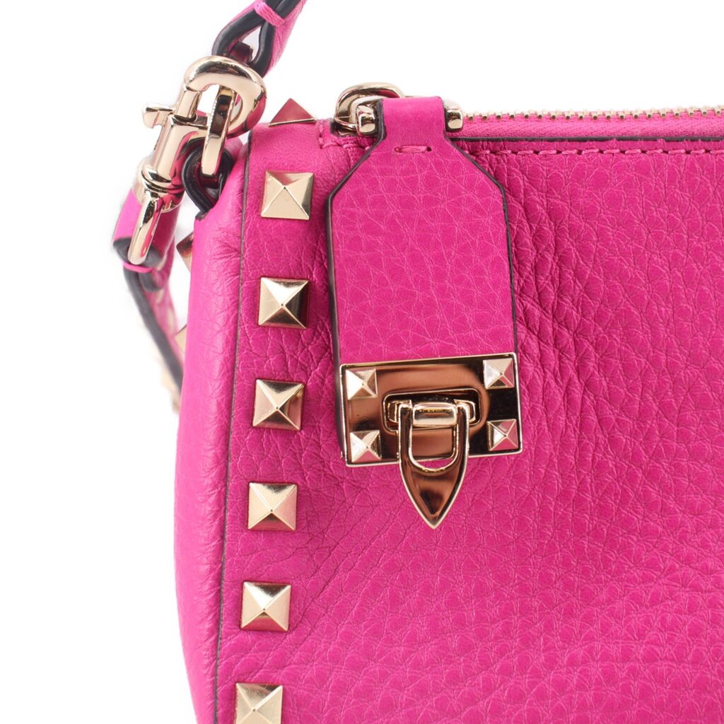 Pink crossbody bag front with gold-tone buckle hardware and small square Rockstuds
