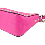 Pink pebbled leather crossbody bag corner with gold-tone studs and trim strap