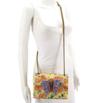 Kurt Geiger floral crossbody bag worn with long chain strap and jeweled bow