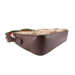 Close side view of tan GG monogram crossbody bag with brown leather edge and web strap