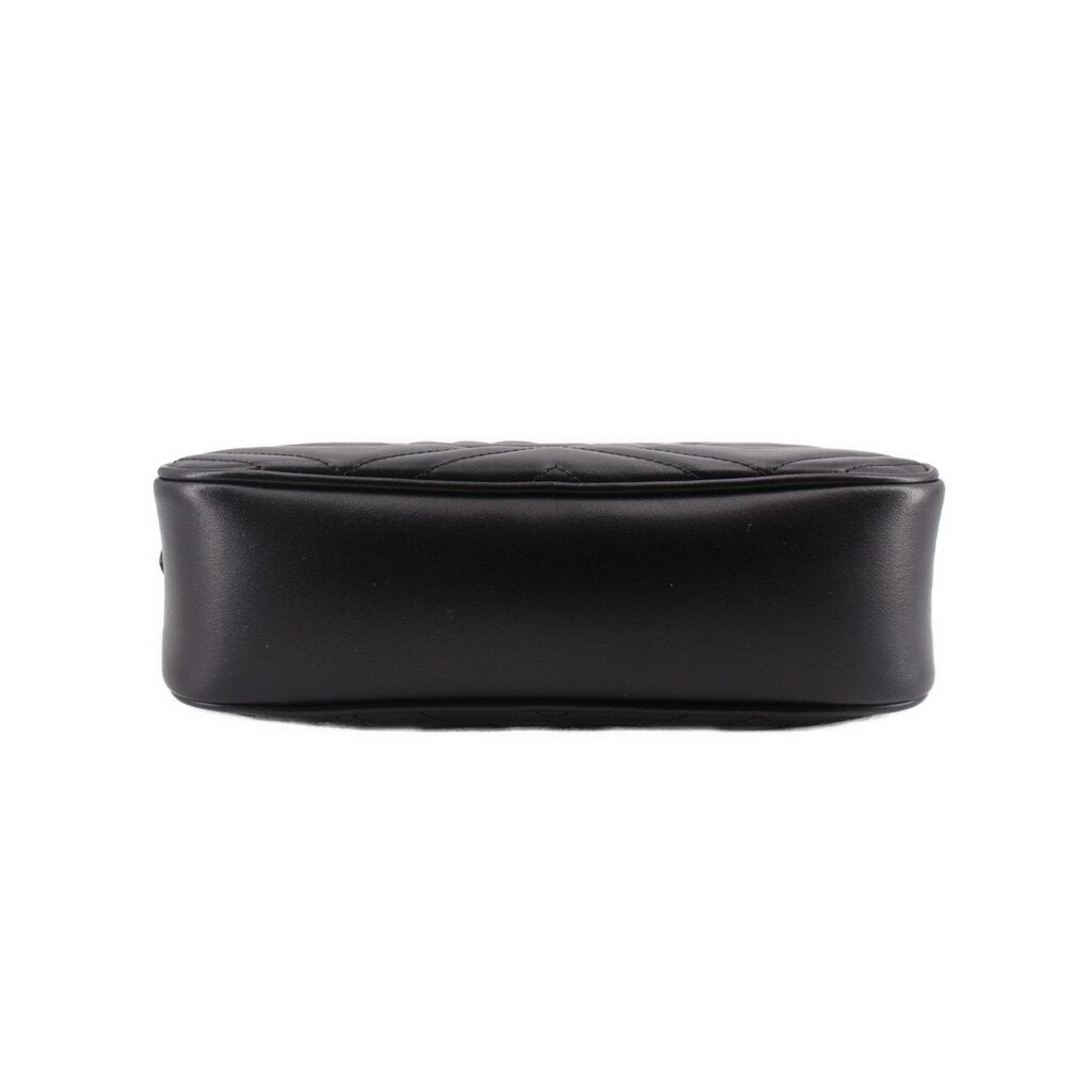 Black leather camera crossbody bag back panel with minimal branding and smooth finish.