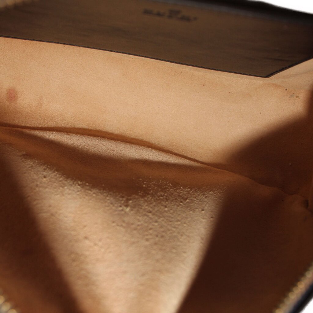 Black leather interior lining of a camera crossbody bag, with stitching and seam detail.