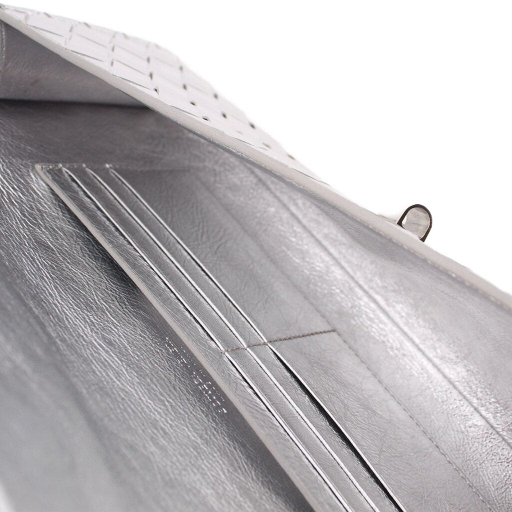 Silver leather-lined clutch interior close-up with stitched seams and panels