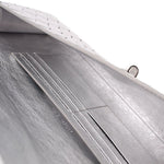 Silver leather-lined clutch interior close-up with stitched seams and panels