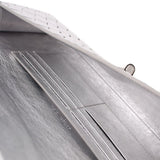 Silver leather-lined clutch interior close-up with stitched seams and panels