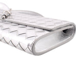 Silver metallic clutch corner close-up with woven pattern and folded edge